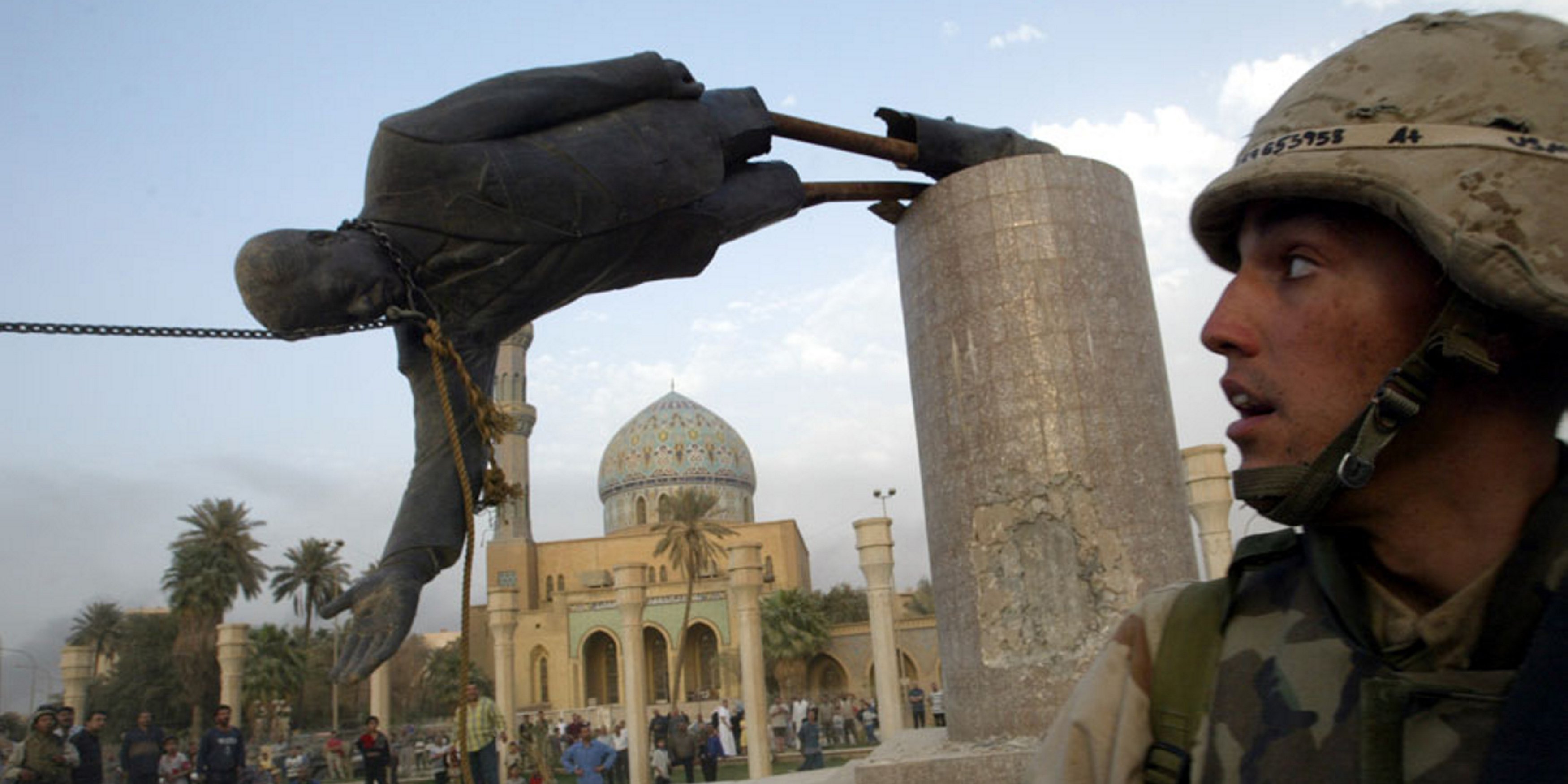 A U.S. marine watches as a statue of former Iraqi President Saddam Hussein is brought down in central Baghdad, on April 9, 2003. 
