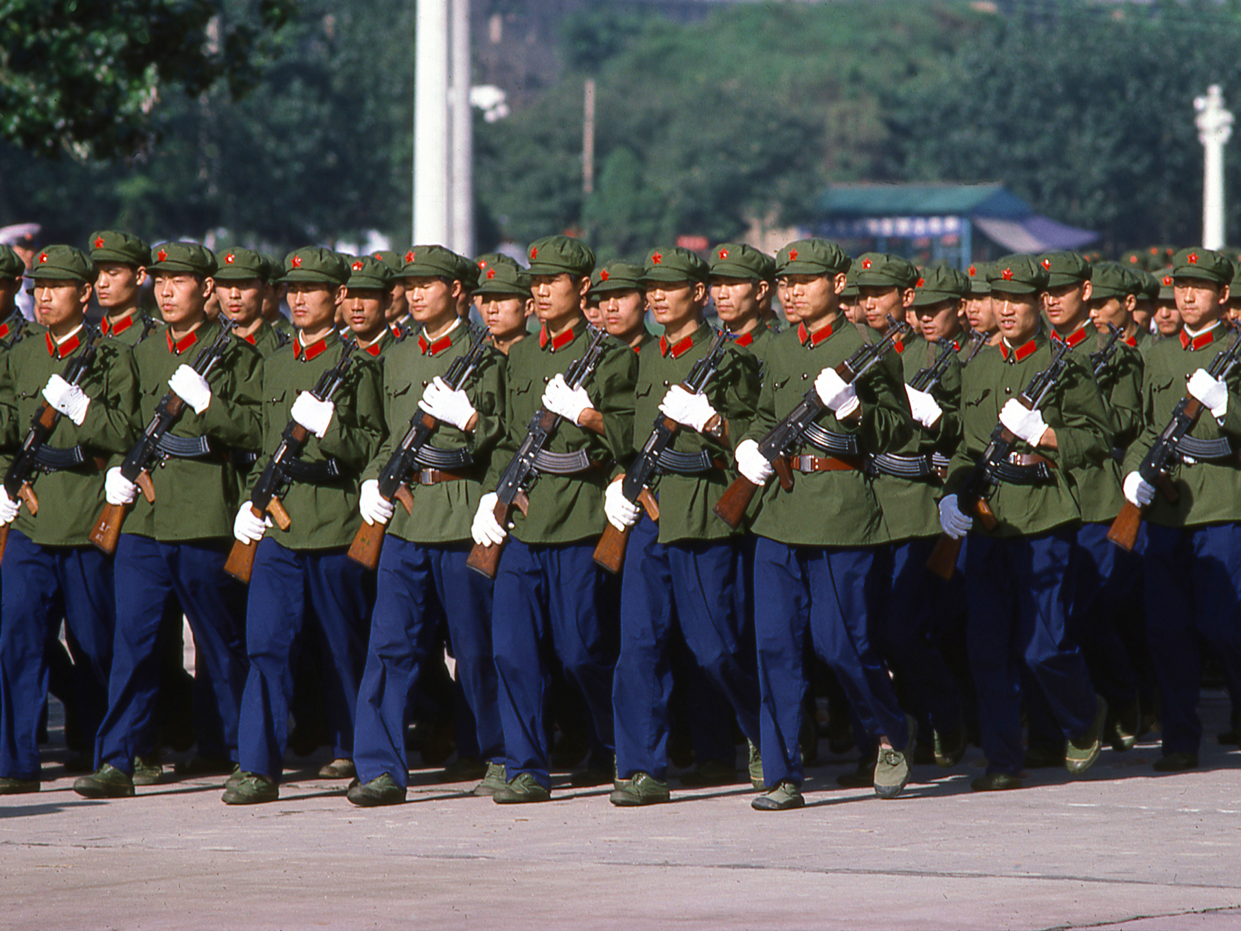 A photo showing Chinese People's Liberation Army soldiers carrying rifles and marching down a street in Xian, China, circa 1979.
