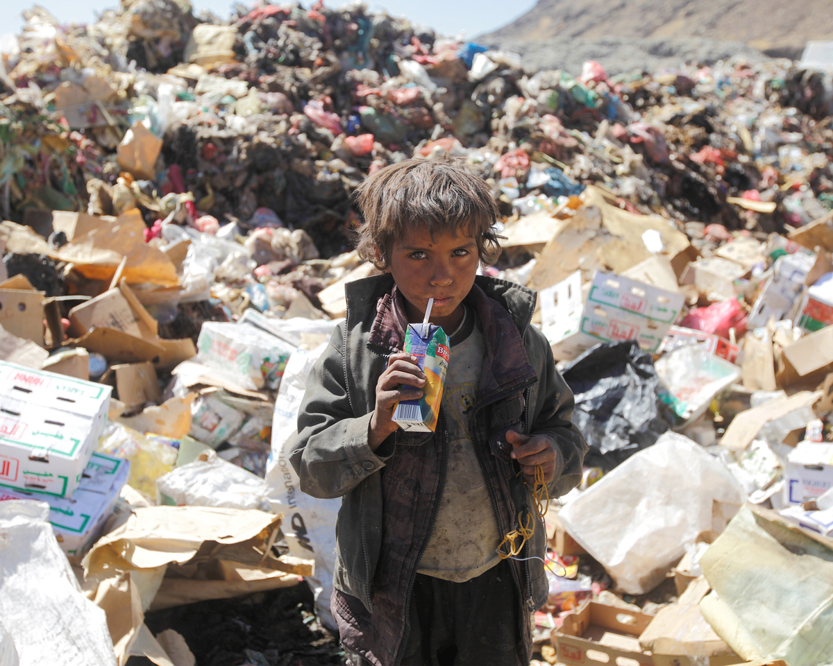 A photo showing a Yemeni boy drinking expired juice at a landfill on the outskirts of Sanaa, Yemen, on November 16, 2016.