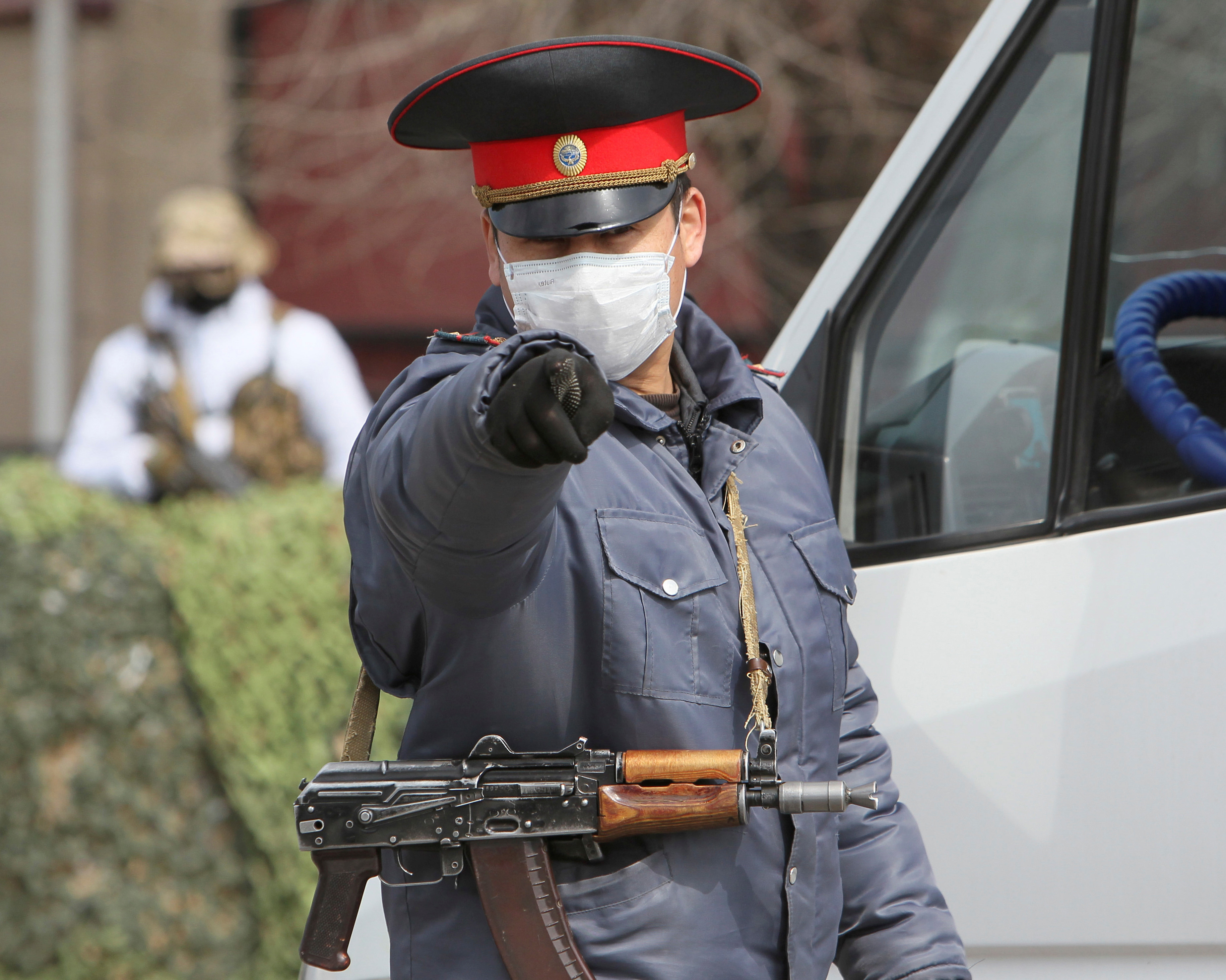 A photo showing a Kyrgyz law enforcement officer gesturing while verifying drivers and passengers' documents at a checkpoint on the outskirts of Bishkek, Kyrgyzstan, on March 26, 2020.