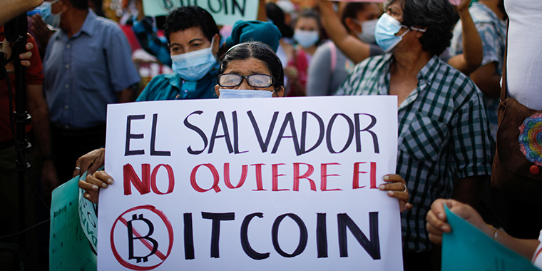A person holds a sign that reads "El Salvador doesn't want Bitcoin" as people participate in a protest against the use of Bitcoin as legal tender, in San Salvador, El Salvador, on September 7, 2021.