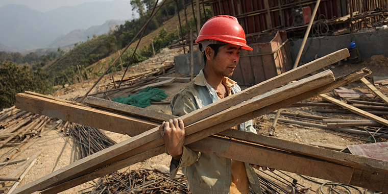 A Chinese worker carries materials for the first rail line linking China to Laos, a key part of Beijing's Belt and Road Initiative across the Mekong, in Luang Prabang on February 8, 2020.