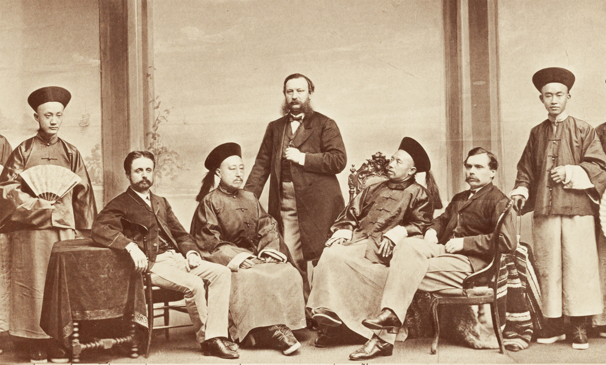 Black and white photo from 1868 showing American lawyer Anson Burlingame standing with two European and a group of Chinese men.