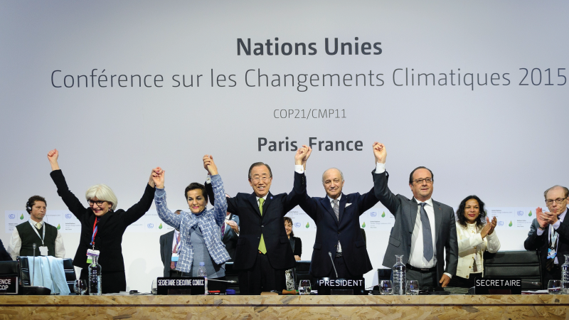 United Nations leaders and French President Francois Hollande (right) raise their hands in triumph after adopting the historic global warming pact known as the Paris Agreement at the 21st Conference of Parties (COP) in Le Bourget, north of Paris, on Decem