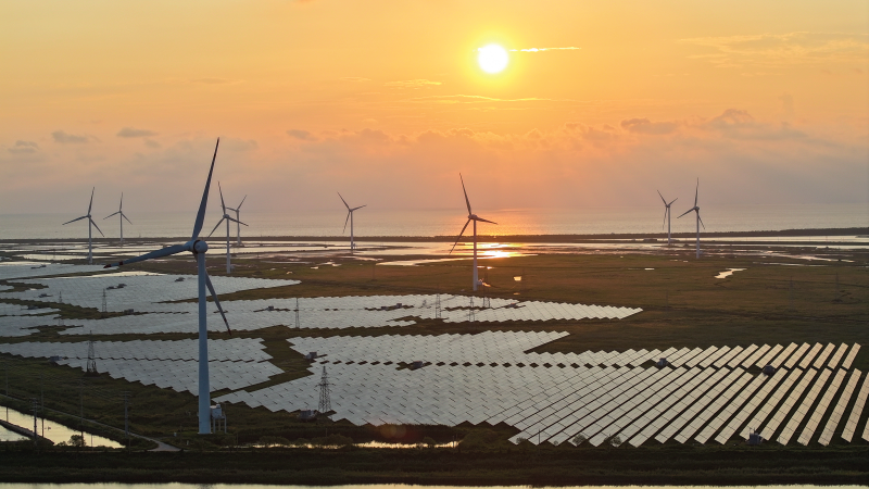 Wind turbines spin above solar panels in Yancheng, China on August 15, 2024. 