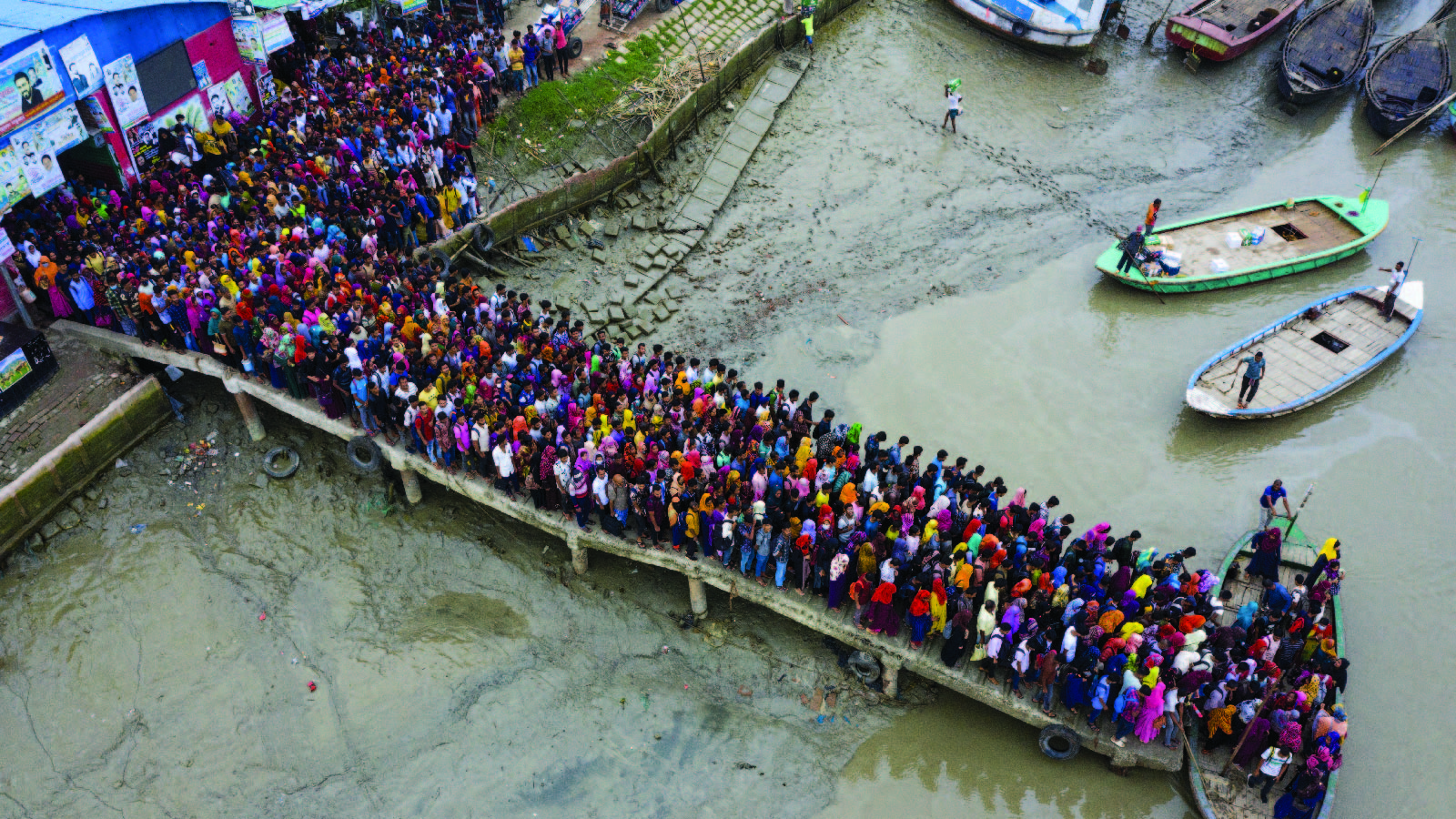 A large crowd of climate migrant workers head to work by boat in Mongla, Bangladesh