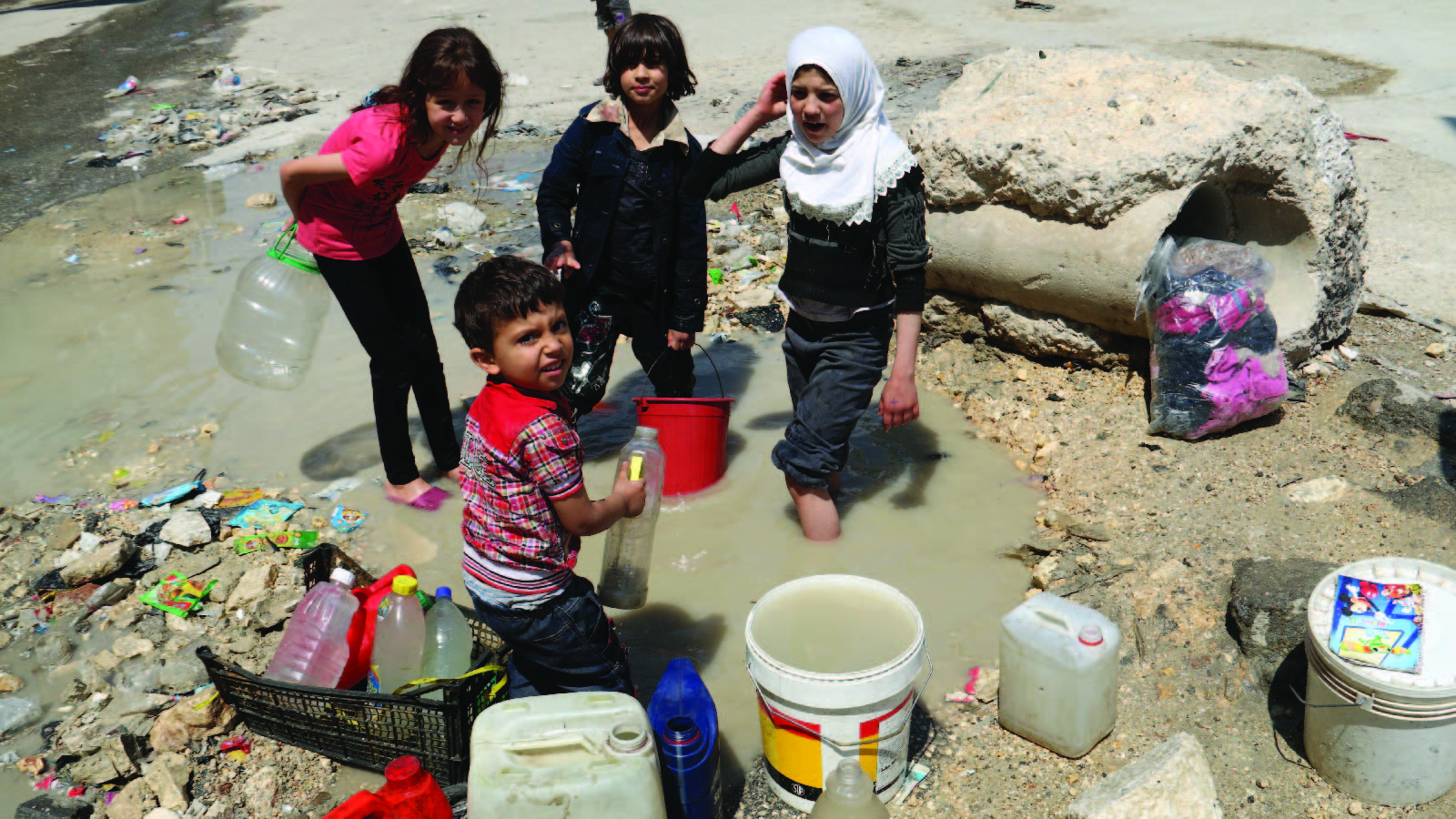 Children in a rebel-held area of Aleppo, Syria, collect stagnant, murky water on May 12, 2014. Residents had been without water for over a week as jihadists have cut supplies to both rebel and regime-held areas.