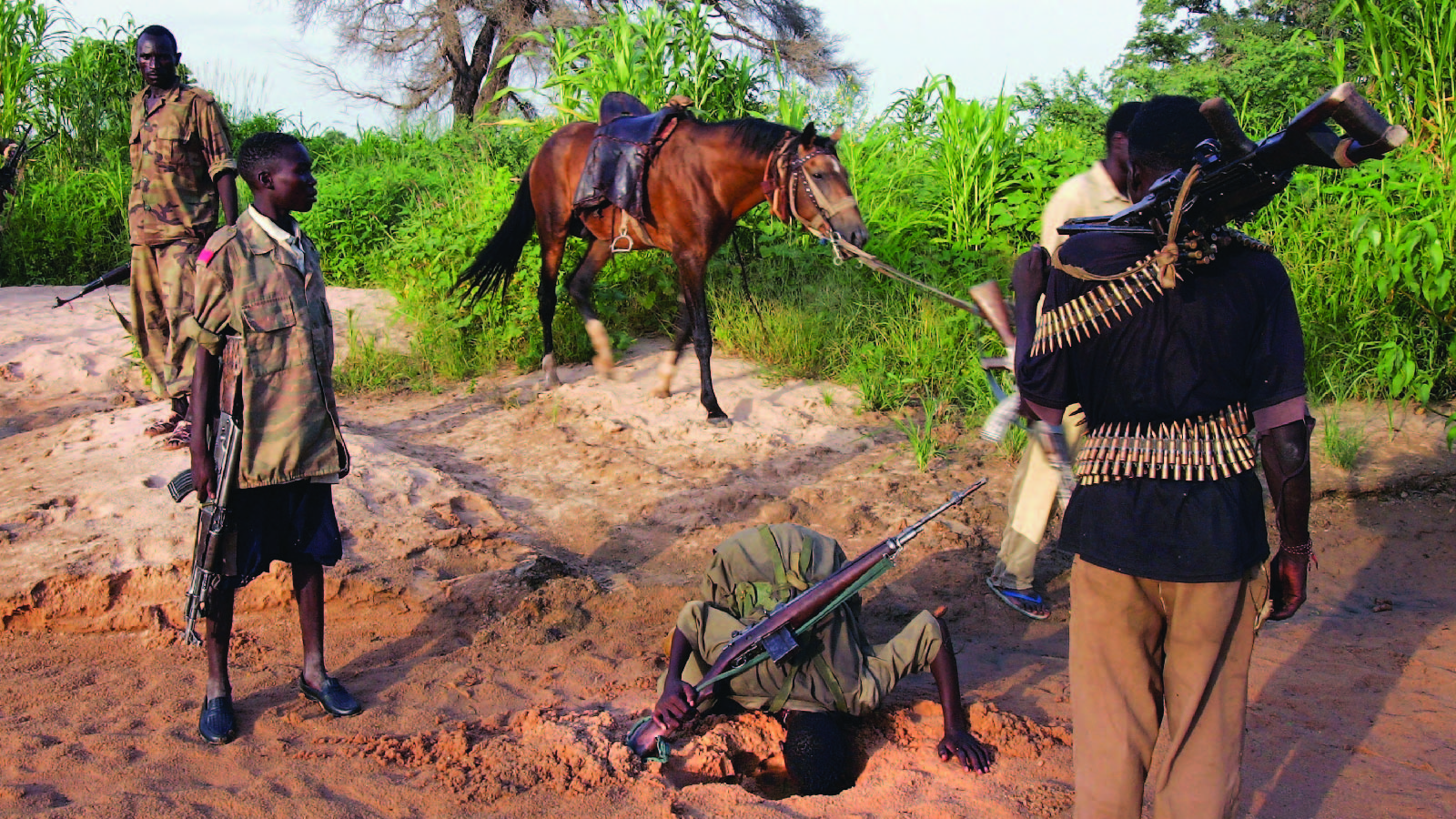 Rebel fighters from Sudan’s Justice and Equality Movement dig for water in a creek bed while patrolling near their base in Darfur, Sudan.