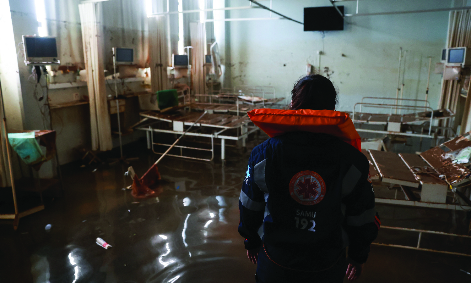 An emergency worker surveys a hospital emergency room destroyed by floods in Canoas, Brazil