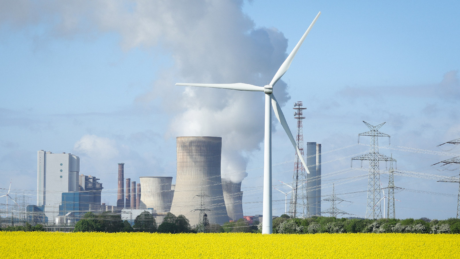 Wind turbines operate in a field in front of a coal-fired power plant in Ingendorf, Germany