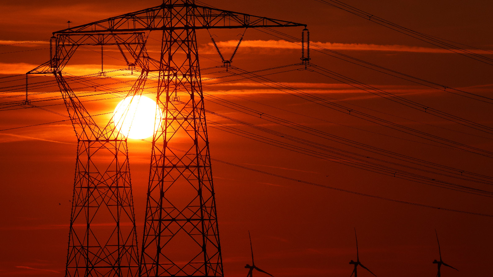 Electricity power lines and power-generating windmill turbines operate in Avesnes-le-Sec, France 