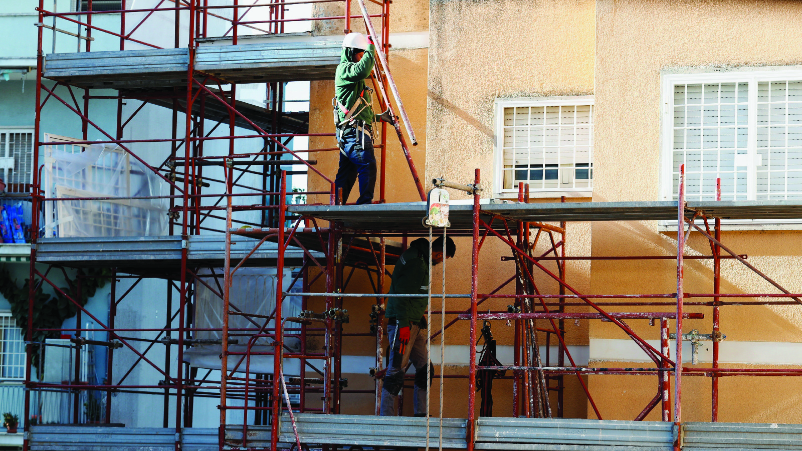 Builders work at the construction site of an energy-saving building in Rome, Italy, on February 1, 2023. 