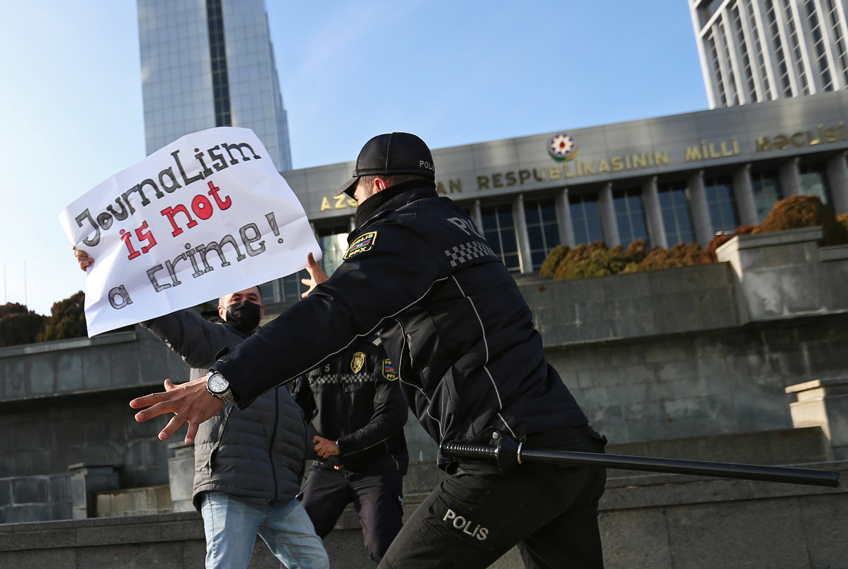 Police officers restrain a protester during a rally of journalists against a new media bill, in front of the Parliament building in Baku, Azerbaijan December 28, 2021. 