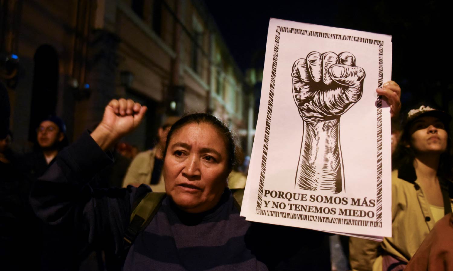 A woman holds up a sign that reads: "because there are more of us and we are not afraid" at a speech by Guatemala's President Bernardo Arevalo.