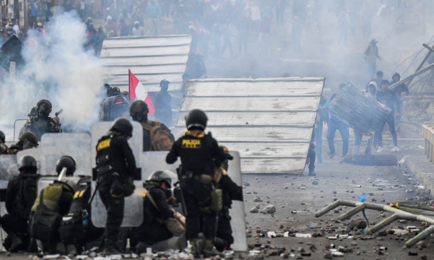 Smoke fills the air as demonstrators clash with riot police at the Añashuayco bridge in Arequipa, Peru.