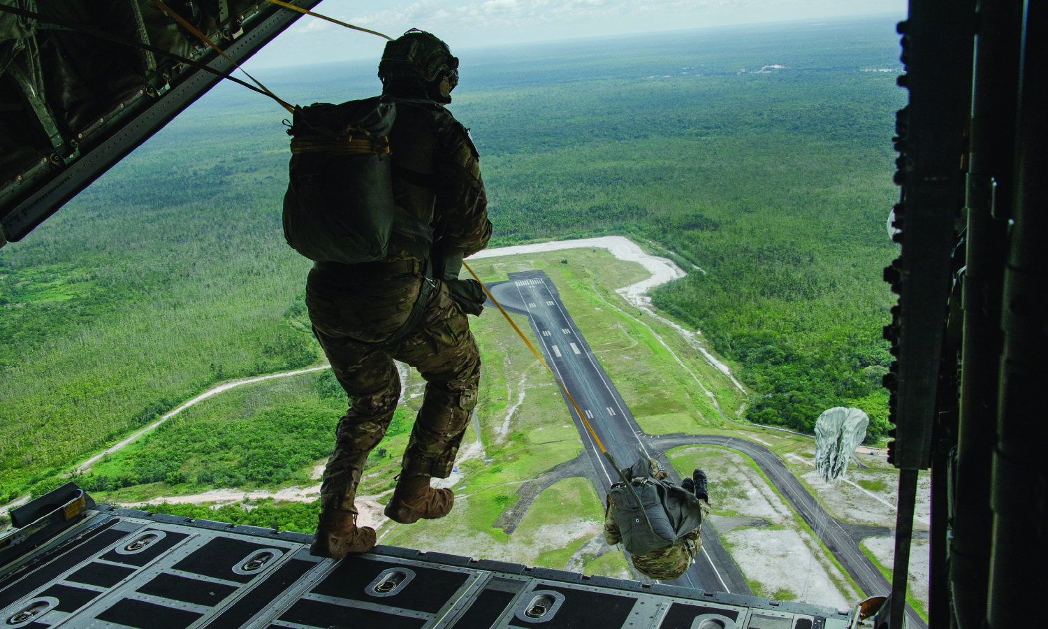 Tactical Air Control Party specialists with the 137th Special Operations Wing, Oklahoma National Guard, conduct a static line jump during an exercise over Air Base London, Guyana, on July 18, 2023. 