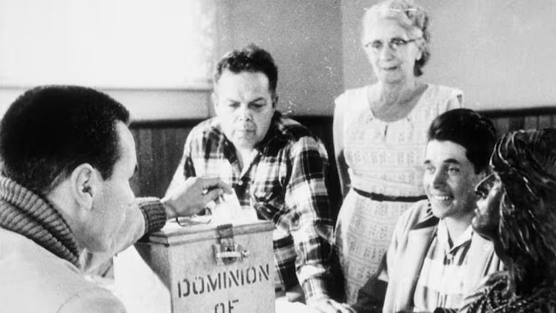 A black and white image of a polling station in the Hiawatha Council Hall on Oct. 31, 1960. From left: Lawrence Salleby; Chief Ralph Loucks, deputy returning officer; Lucy Muskratt, poll clerk; Eldon Muskratt, poll constable.