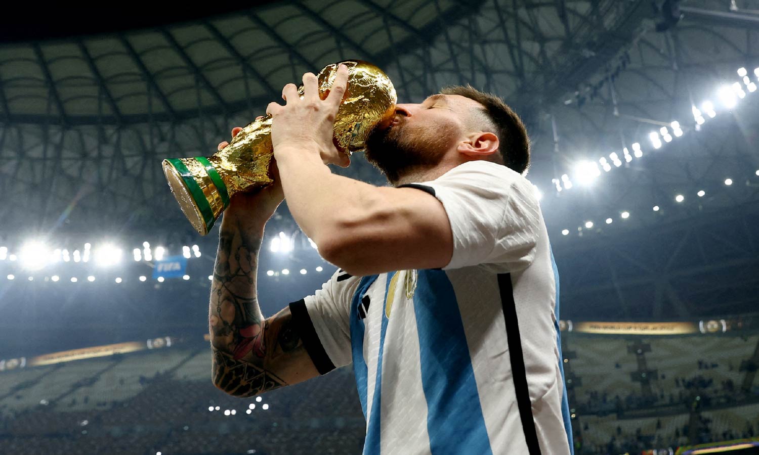 Argentina's Lionel Messi holds up and kisses the trophy as he celebrates winning the World Cup.