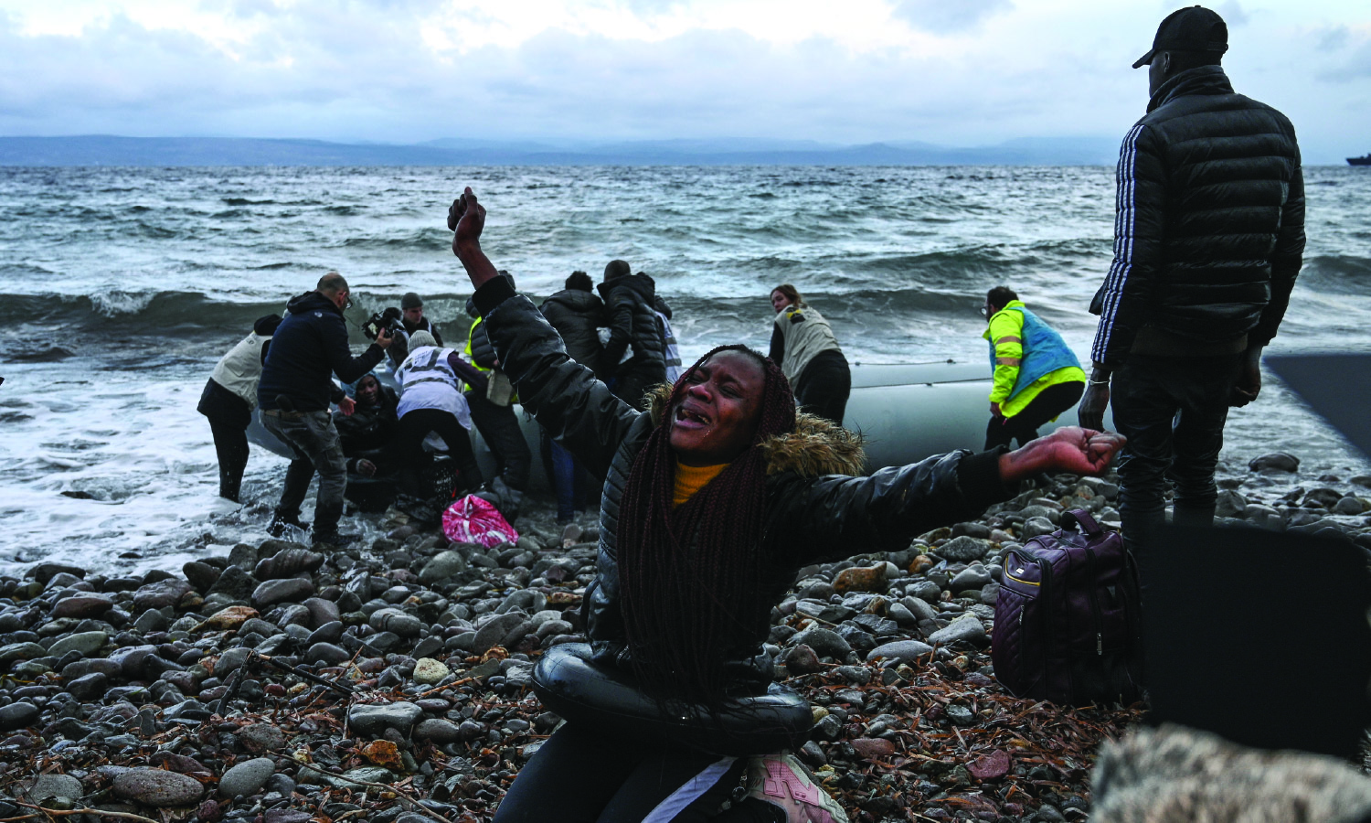 A woman reacts after a warship rescued her during a migrant sea crossing from Gambia and the Republic of Congo; the vessel landed on Lesbos Island on February 29, 2020.