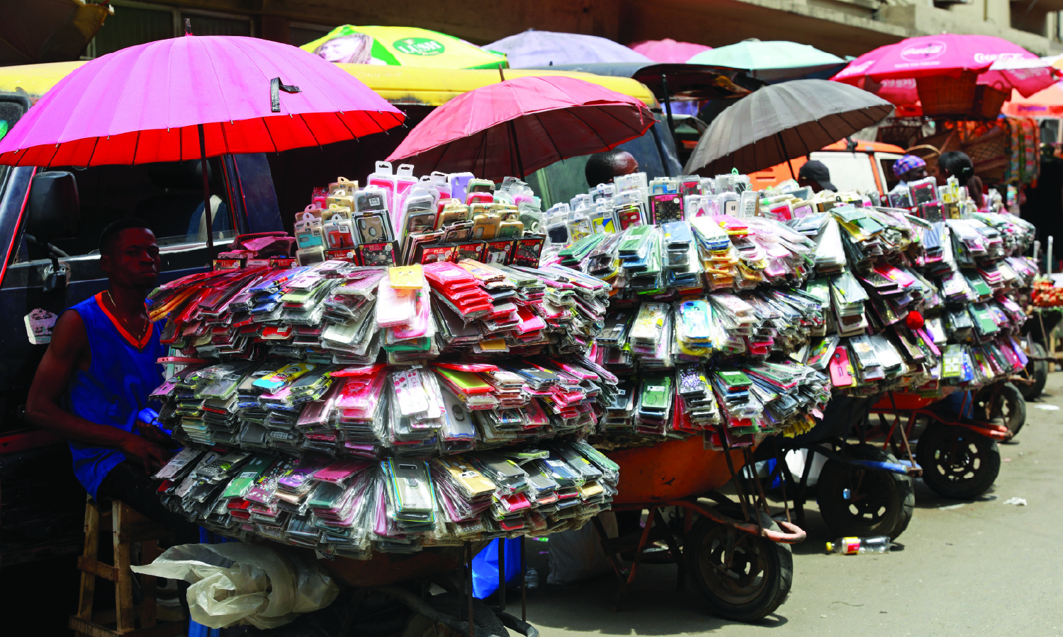 A phone accessory vendor sits beside his goods, hundreds of phone cases, in Lagos, Nigeria.