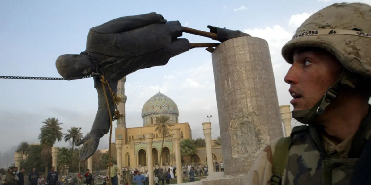 A U.S. marine watches as a statue of former Iraqi President Saddam Hussein is brought down in central Baghdad, on April 9, 2003. 