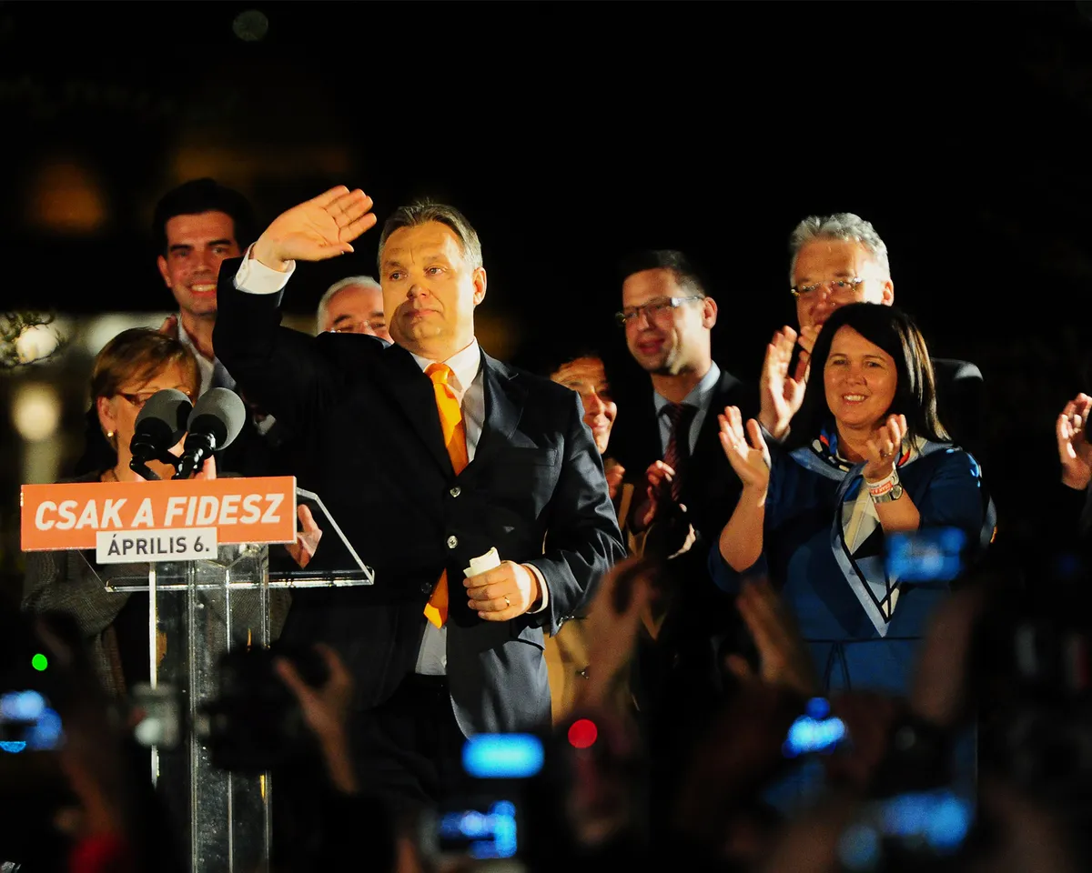 A photo showing Hungarian Prime Minister Viktor Orban waving to supporters after winning the parliamentary elections with members of his populist, right-wing Fidesz party on April 6, 2014 in Budapest.