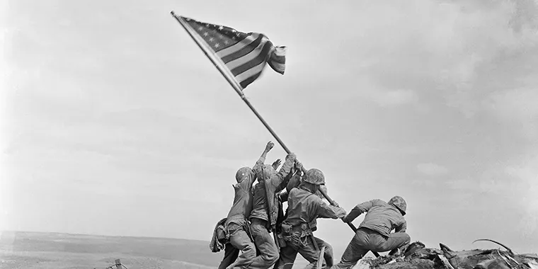 Marines raise the U.S. flag atop Mount Suribachi during the Battle of Iwo Jima on February 23, 1945.