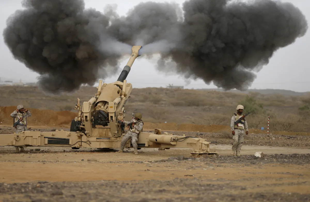 Black smoke spews out of the mouth of a Saudi artillery cannon as it fires toward Houthis.