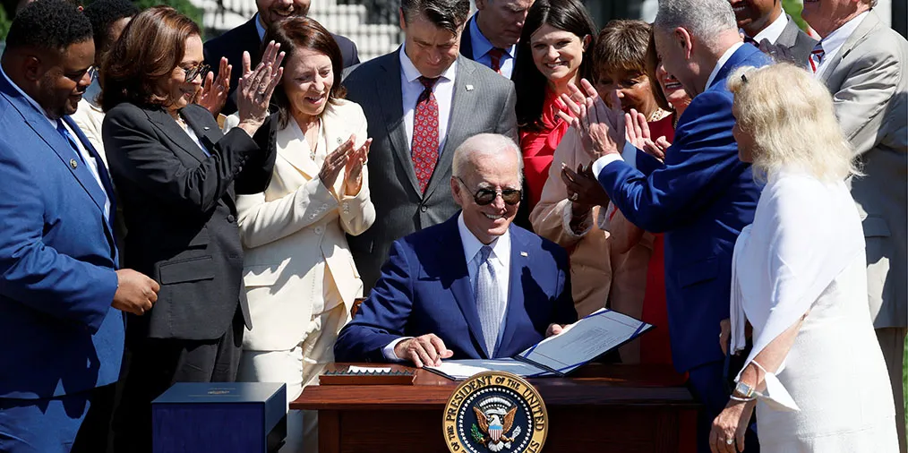 U.S. President Joe Biden signs the CHIPS and Science Act of 2022 on the South Lawn of the White House in Washington D.C. surrounded by members of congress. 