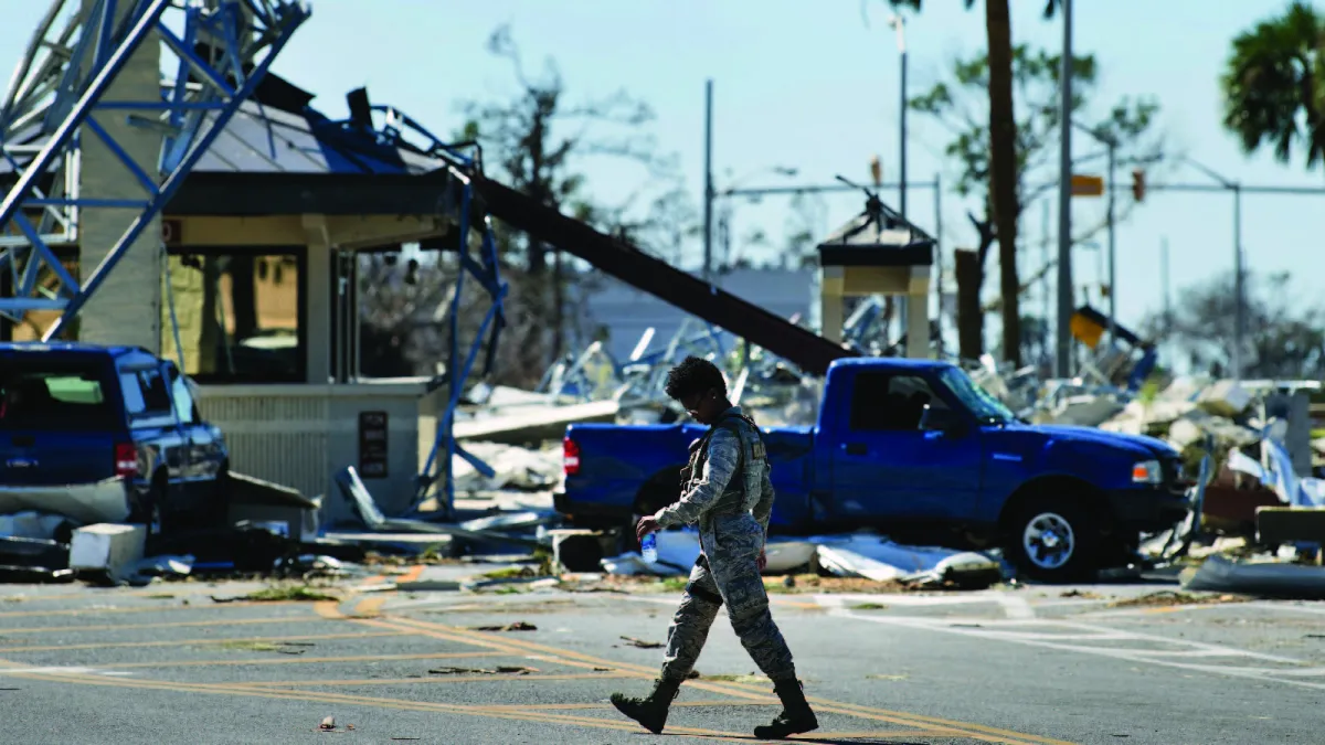 A military police officer walks past damage at Tyndall Air Force Base caused by Hurricane Michael near Panama City, Florida