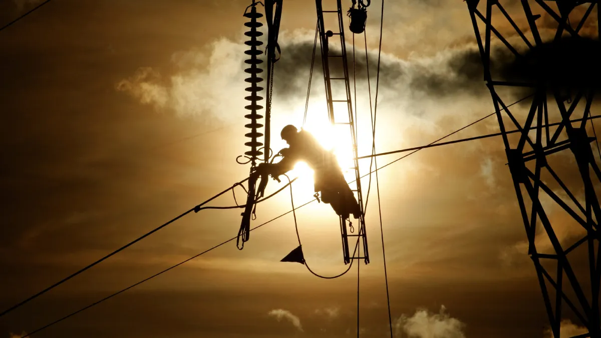 A maintenance technician repairs electricity power lines during sunset in Roye, France, on February 11, 2019.