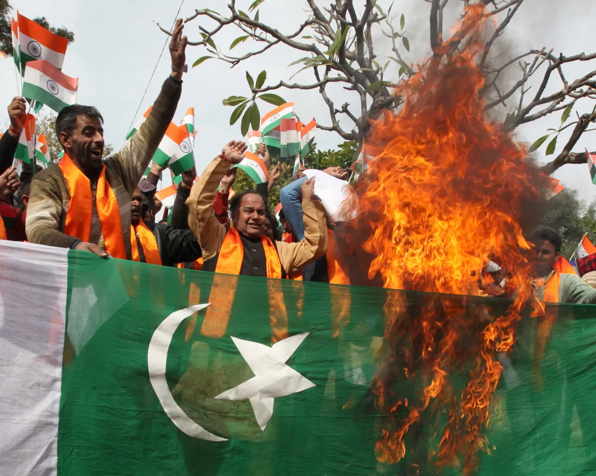 An image of supporters of multiple Hindu nationalist groups waving Indian flags and burning the Pakistan national flag during a protest rally in Jammu.