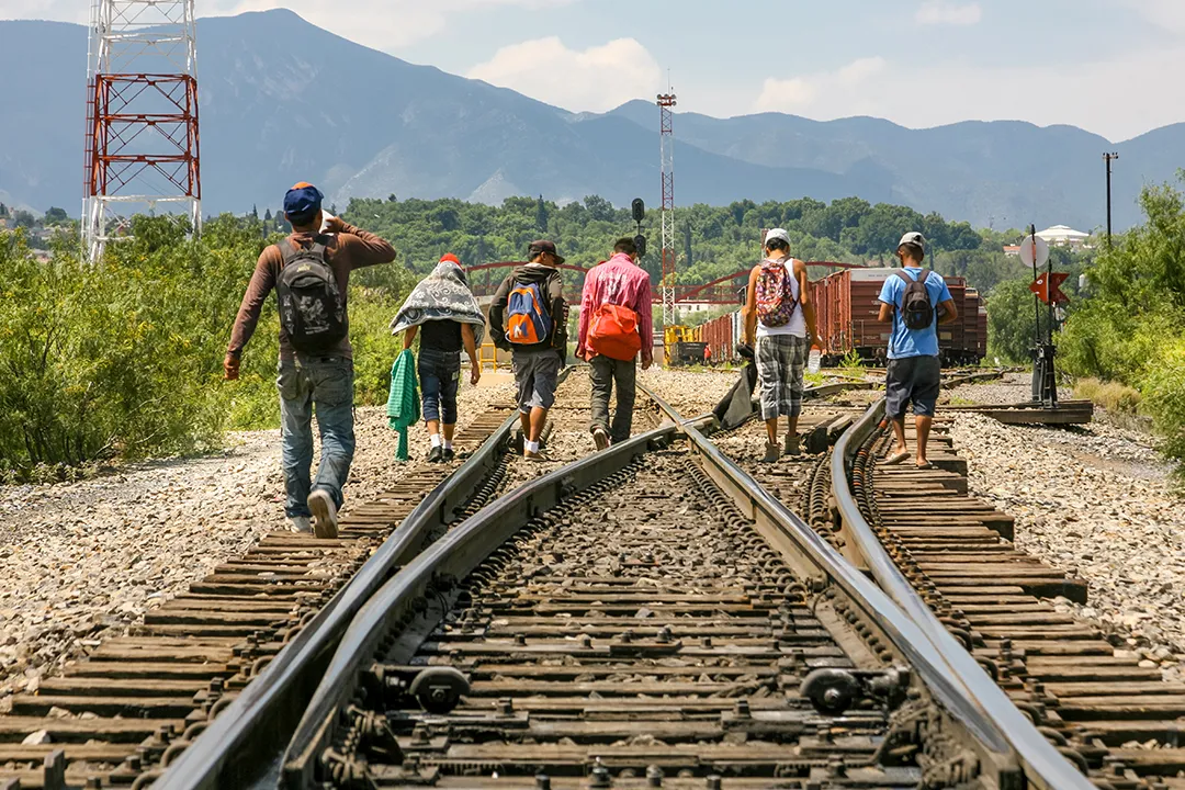 A group of migrants from Central America wait on the railway line to get on a container train, known as 'The Beast', to go to the border of the United States and Mexico.