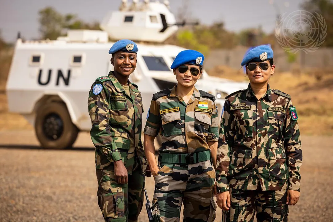 Three female peacekeepers from Malawi, India, and Nepal pose for a photo at the United Nations Camp in Juba, South Sudan.