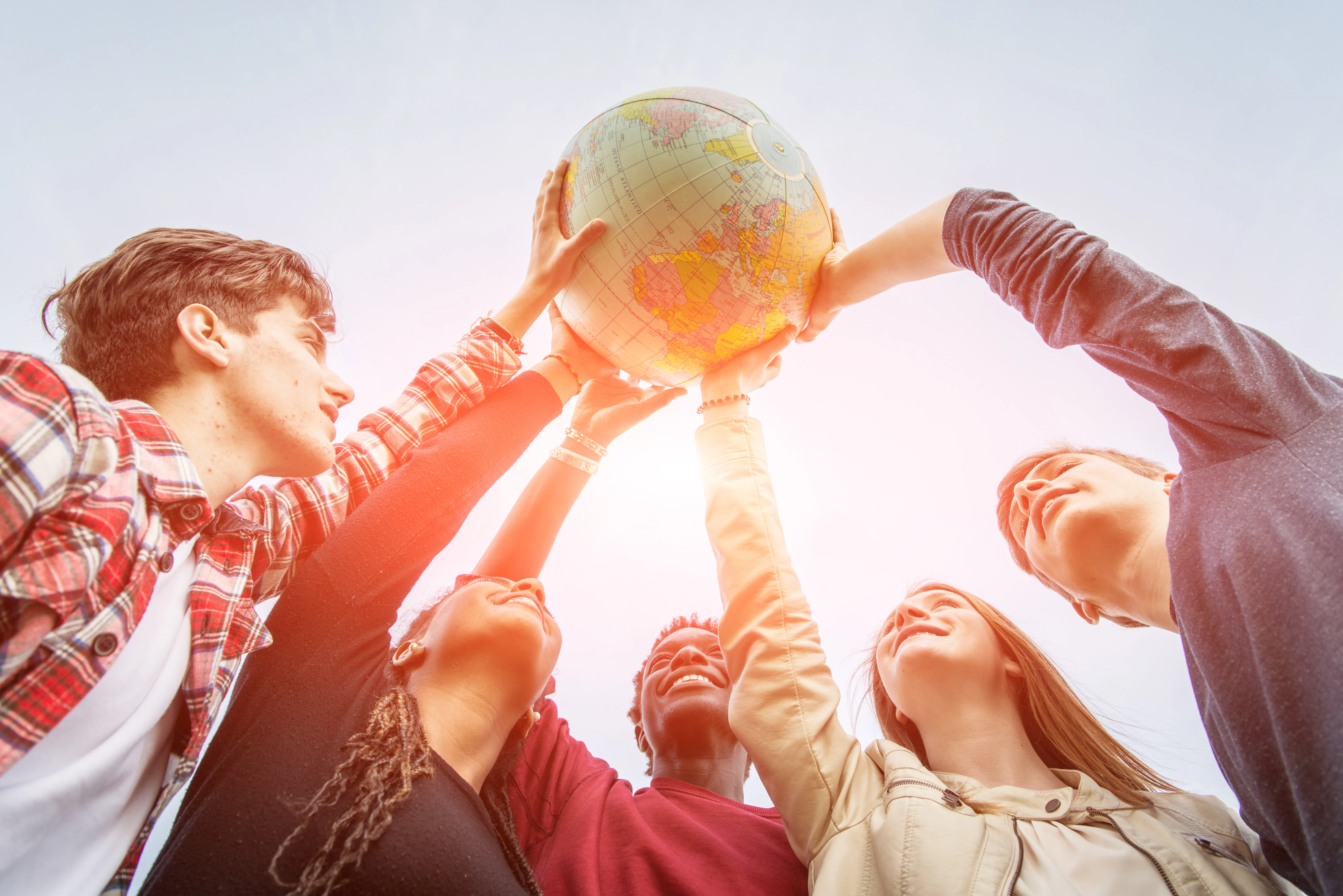 kids holding up globe