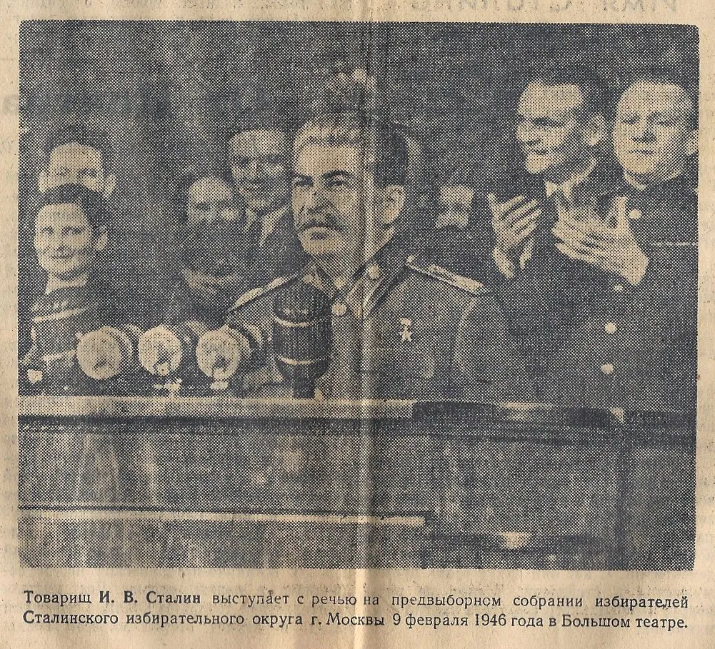 A newspaper clipping of Stalin making a speech at a podium as others stand behind him.