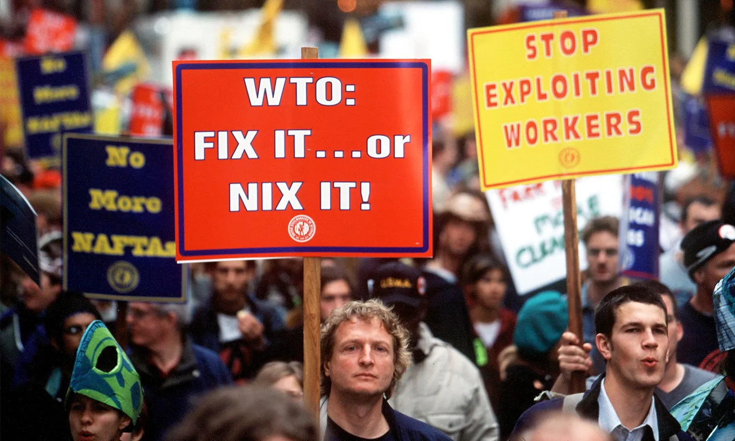 Anti-globalization protestors hold signs outside the WTO Ministerial Conference on November 29, 1999. 